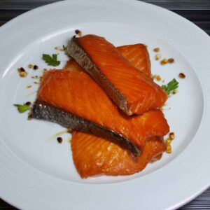 Natural smoked spring salmon sticks on a white plate